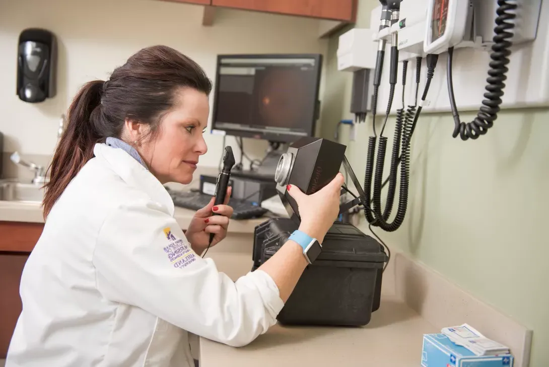 Nursing student working with equipment in exam room