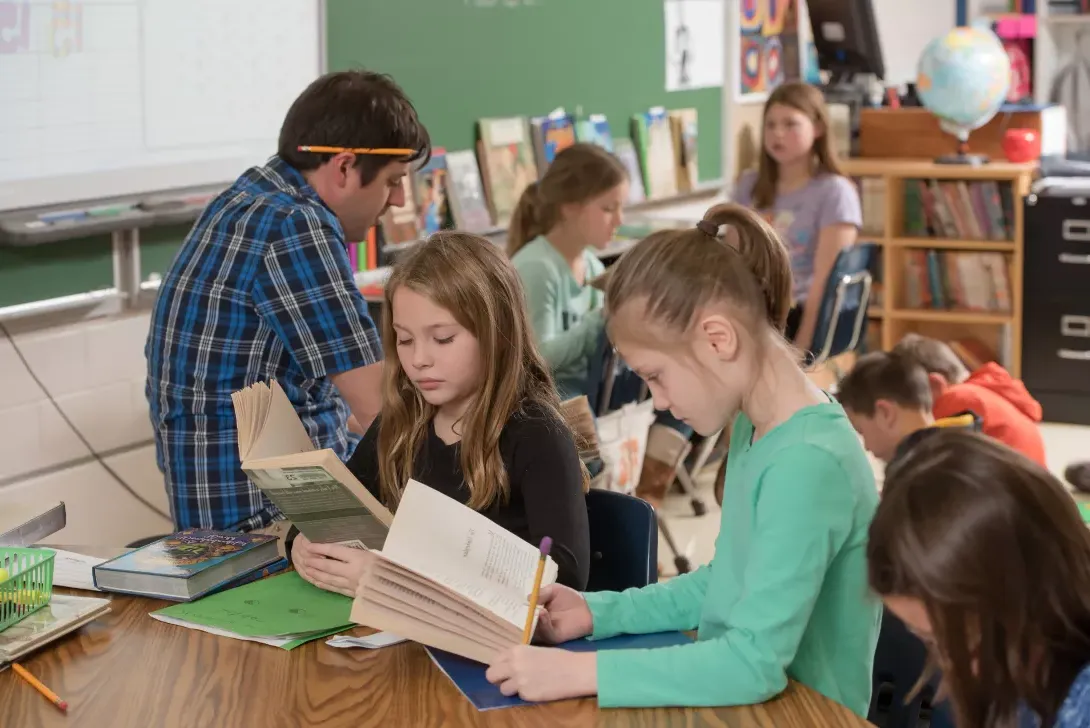 Student teacher and students reading in classroom